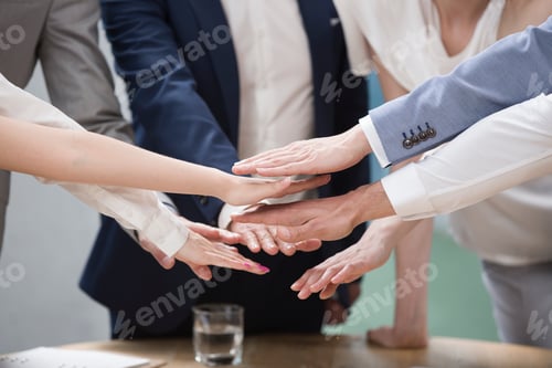 Preview: Confident business people stacking hands in meeting room