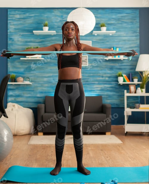 Preview: African doing home workout in living room with rubber band