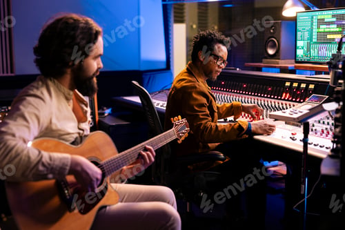 Preview: Composer playing a new hit song on his guitar in studio control room