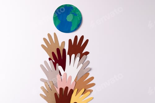 Preview: Paper cut out of multi coloured hands with globe and copy space on white background