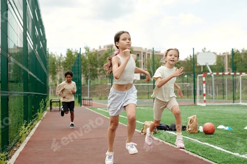 Preview: Active schoolgirl in white sportswear leading in running competition