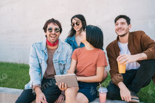 Preview: Friends using digital tablet together outdoors.