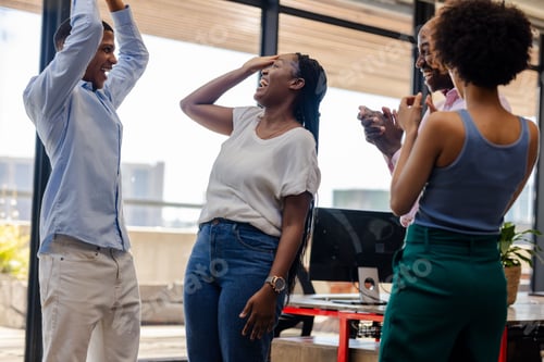 Preview: Colleagues celebrating success in office, smiling and clapping with excitement