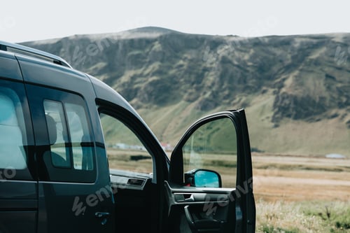 Preview: Caravan van is stand with open doors in front of an iceland mountain during a road trip.Vanlife - li
