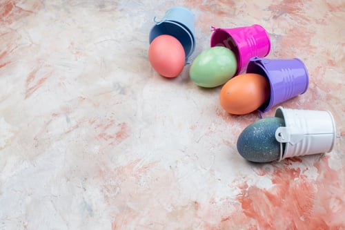 Preview: front view colored easter eggs inside separate little baskets on the light background ornate spring