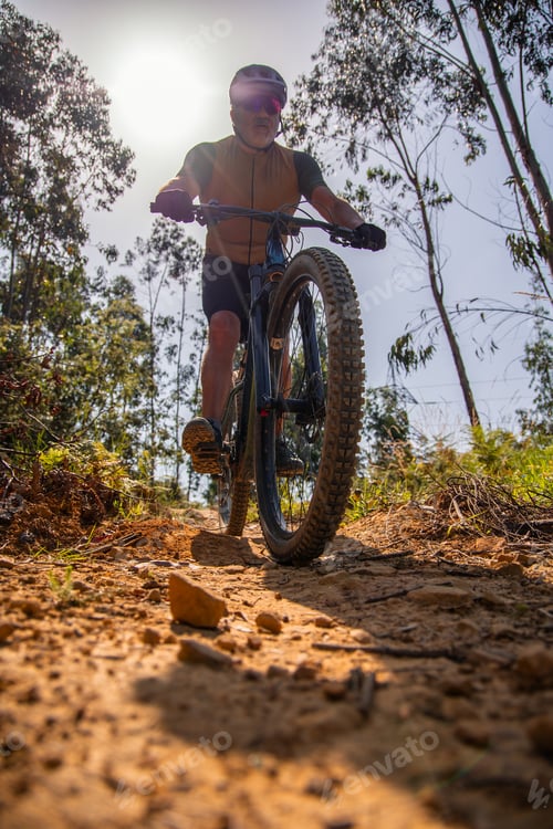 Preview: Senior cyclist enjoying electric mountain bike ride on sunny trail
