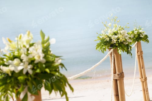 Preview: Bush of flowers bouquet and green leaves on the bamboo vase. Wedding venue outdoors decoration.