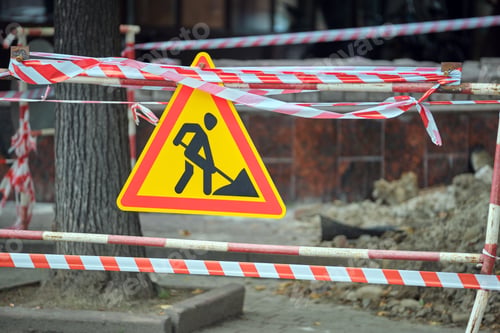 Preview: Warning roadworks sign and safety barrier on city street during maintenance repair work