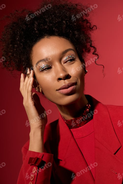 Preview: Striking portrait of a young woman with curly hair in a vibrant red setting