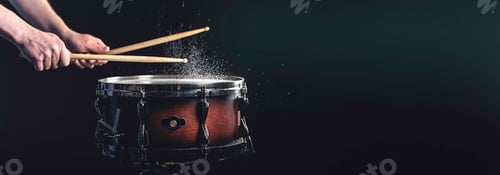 Preview: A man plays a snare drum on a dark background, copy space.
