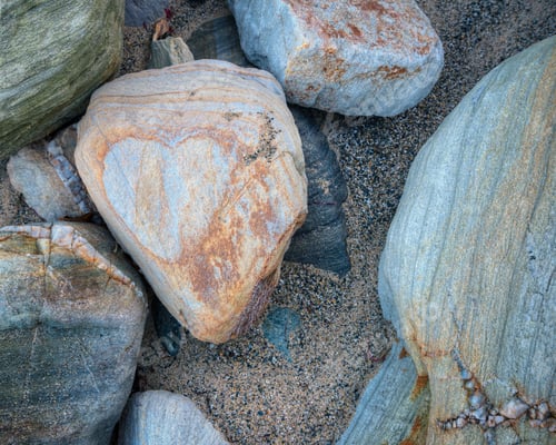 Preview: Heart formed by the reddish pigments of a sandstone pebble on a beach