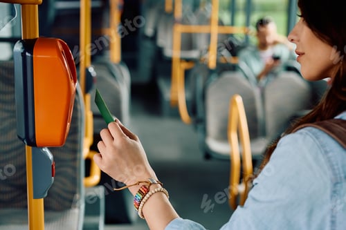 Preview: Close up of woman using validating card while onboarding in a bus,