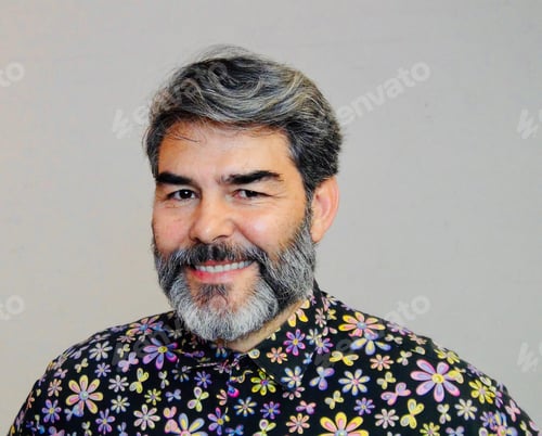 Preview: Portrait of a handsome bearded middle aged man smiling wearing a flower button-down shirt