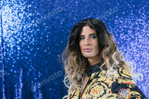 Preview: Confident drag queen performer posing against a glitter background.