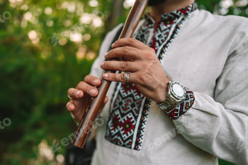 Preview: Hands of young man playing on woodwind wooden flute - ukrainian sopilka outdoors. Folk music concept