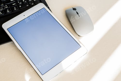 Preview: Tablet with white screen on the keyboard of a laptop on a desk - technology and business concept