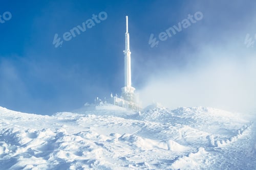 Preview: Snowy landscape with communication tower in mist.
