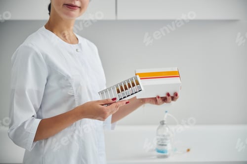 Visualização: Dermatologista mostrando um conjunto de ampolas seladas