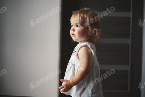 Preview: A little girl of 1.5 years is standing and smiling. The child dances and walks. Cheerful girl in