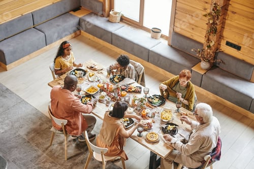 Preview: Large family of six eating by table served with festive food