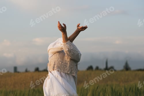 Preview: Young woman with cross hands wearing white dress dancing outdoors. Carefree female outdoors. People
