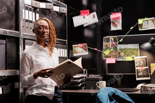 Preview: Confident police detective holding crime case file portrait