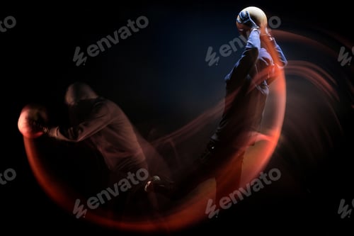 Preview: motion shot of basketball player in black hoodie exercising isolated on black