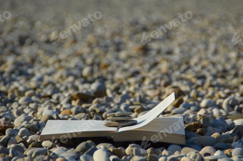 Preview: Closeup shot of an open book on gravel with focus on foreground