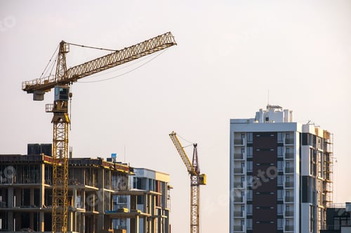 Preview: Tower cranes and high residential apartment buildings under construction. Real estate development.