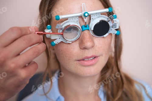 Preview: Happy cheerful woman looking at eye test chart in the ophthalmology center