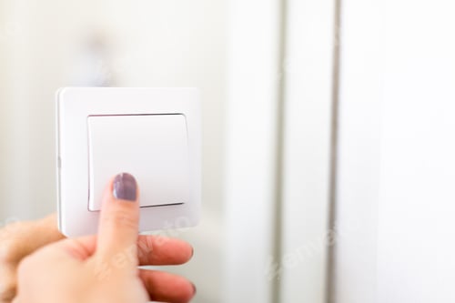 Preview: Turning on the light switch in a bright room with a hand reaching towards it