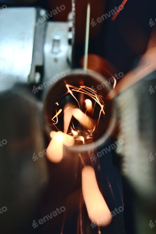 Preview: An angle grinder cuts into a pipe in which many sparks fly towards the camera.