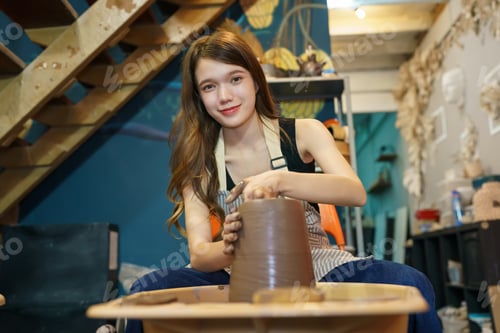 Preview: Woman making pottery in workshop, Shaping wet clay on pottery wheel