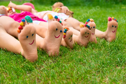 Preview: Children's feet painted on the grass. Selective focus.