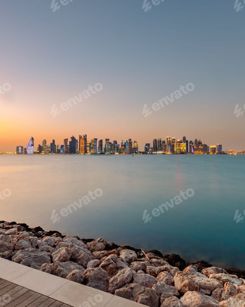 Preview: Aerial view of cityscape Doha surrounded by buildings and water during sunset