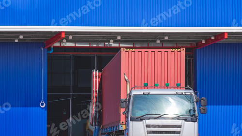 Preview: Trailer truck is unloading construction equipment onto new warehouse building construction site