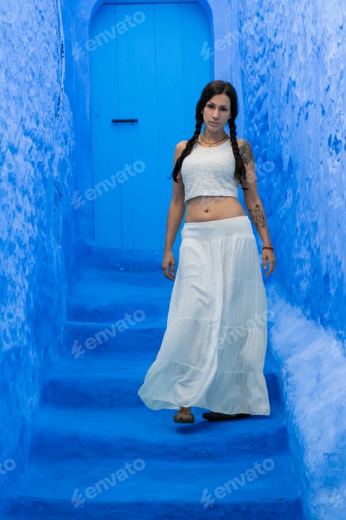 Preview: Young woman looking on blue wall