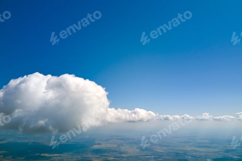 Preview: Aerial view from airplane window at high altitude of earth covered with white puffy cumulus clouds