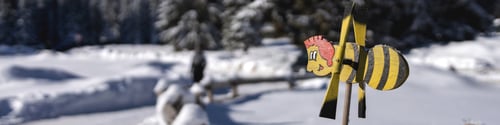Preview: Banner 4x1 with weathervane in form of cheerful bee against of mountains and dense spruce forest