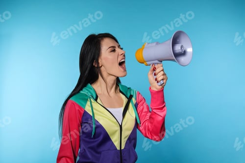 Preview: Portrait of emotional woman using megaphone on color background