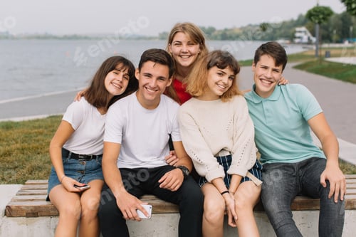 Preview: Summer holidays and teenage concept - group of smiling teenagers hanging out outside.