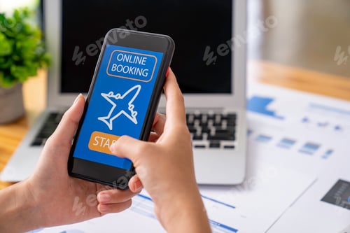 Preview: business woman using a mobile phone in the office to book a plane ticket online via smartphone