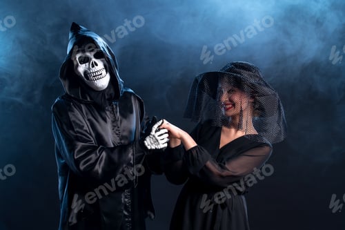 Preview: young woman dressed in black interacting with death itself on dark background grim reaper