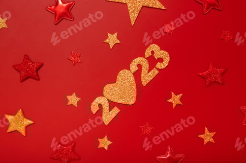Visualização: Conceito de flat lay de ano novo de 2023. Números 2023 com estrelas vermelhas e douradas, vista superior sobre fundo vermelho