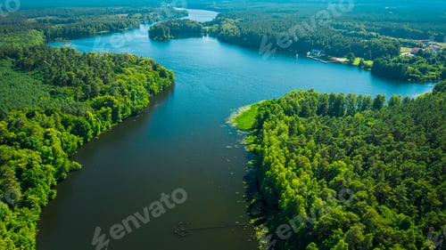 Preview: Big river between green forests at sunrise in summer