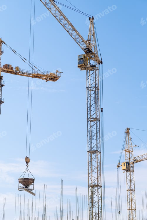 Preview: crane and a building under construction against a blue sky background