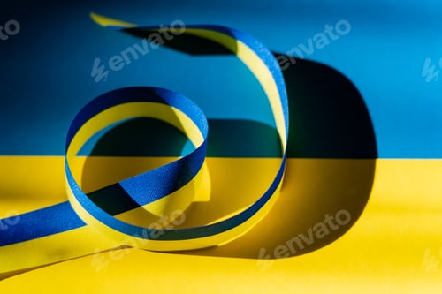 Preview: Close up view of blue and yellow ribbon with shadow on ukrainian flag