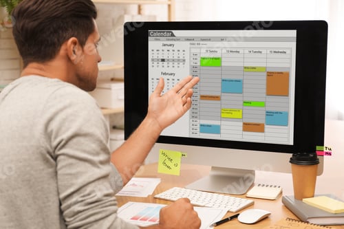 Preview: Handsome man using calendar app on computer in office