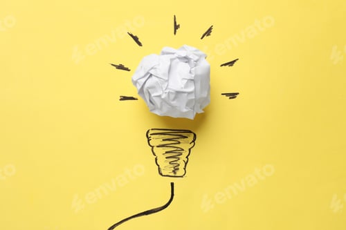 Preview: Idea concept. Light bulb made with crumpled paper and drawing on yellow background, top view