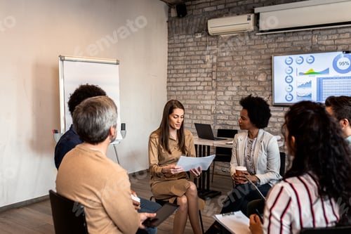 Preview: Group of diverse group of business people having a meeting while sitting in circle.